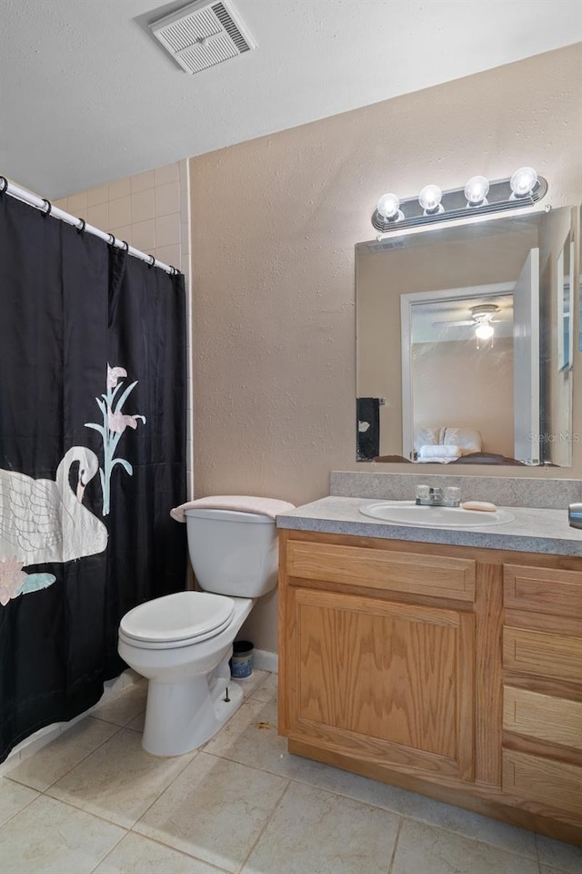 bathroom featuring toilet, tile patterned floors, and vanity