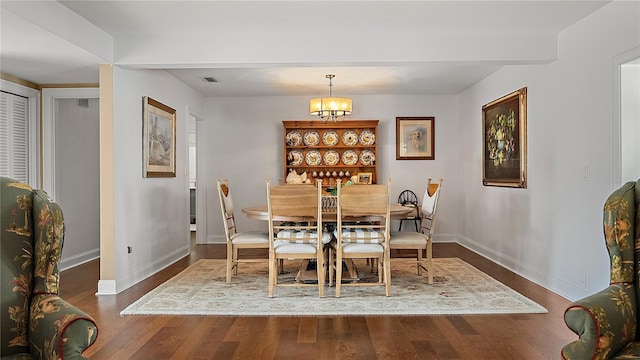 dining room featuring visible vents, dark wood finished floors, baseboards, and an inviting chandelier