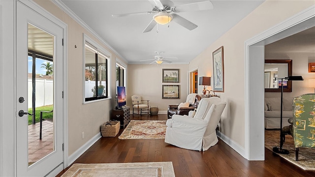 living area with crown molding, dark wood-style flooring, and baseboards