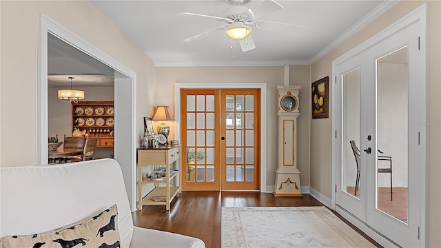 doorway to outside featuring dark wood-style floors, french doors, ornamental molding, baseboards, and ceiling fan with notable chandelier