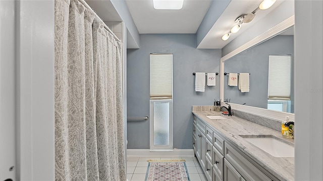 full bathroom featuring double vanity, a stall shower, a sink, and tile patterned floors