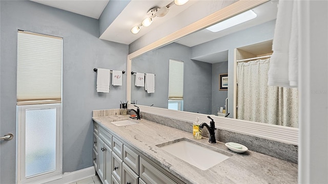 full bathroom with a sink and double vanity