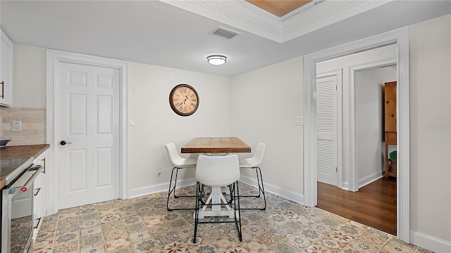 dining space featuring light wood finished floors, visible vents, and baseboards