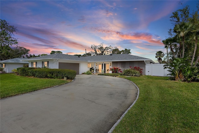 single story home featuring a garage, a yard, concrete driveway, and a gate