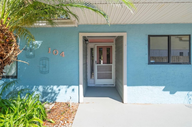 view of exterior entry with stucco siding