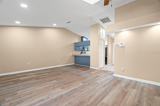 unfurnished living room with visible vents, light wood-style flooring, a ceiling fan, baseboards, and lofted ceiling