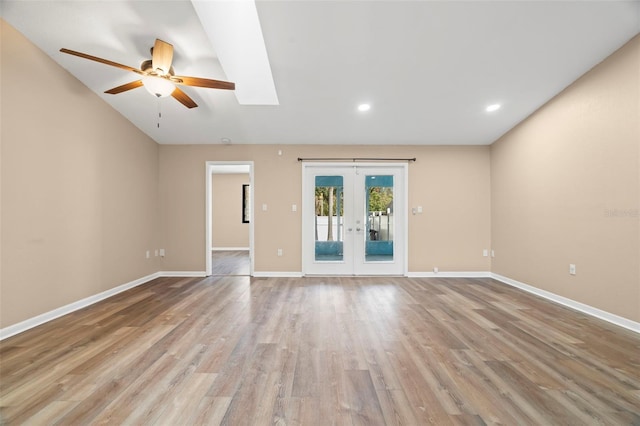 empty room featuring ceiling fan, french doors, light wood-type flooring, and baseboards