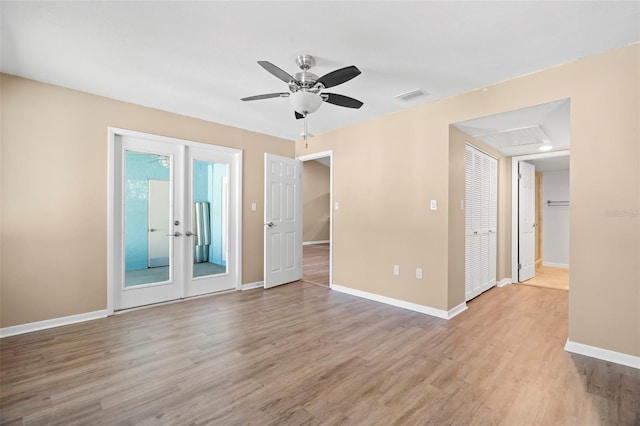 unfurnished room with visible vents, a ceiling fan, wood finished floors, french doors, and baseboards