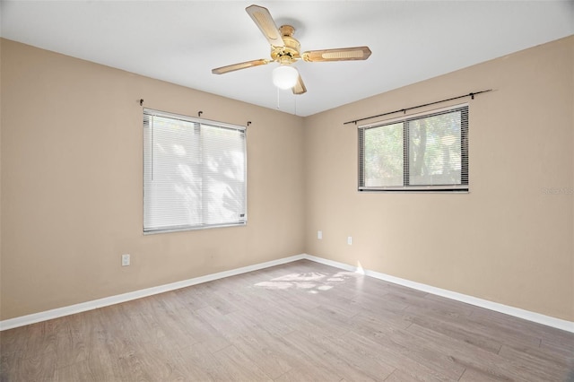 spare room with ceiling fan, baseboards, and wood finished floors