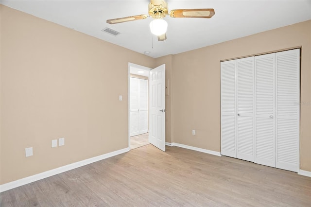 unfurnished bedroom with visible vents, baseboards, a closet, and light wood-style flooring