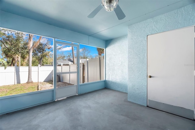 unfurnished sunroom with a ceiling fan