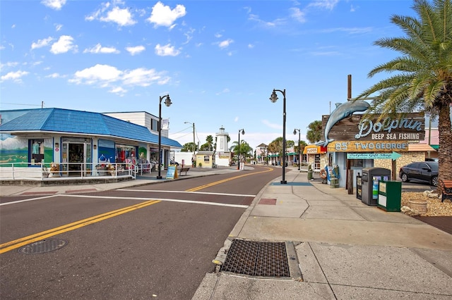 view of street featuring curbs, street lights, and sidewalks