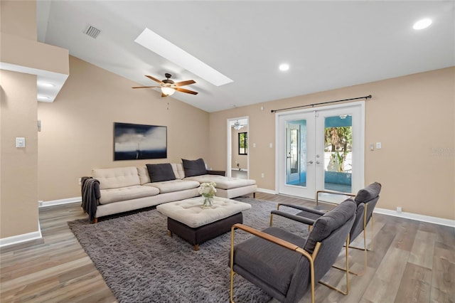 104 Anclote Rd Unit 104, Tarpon Springs, FL 34689 - living room featuring plenty of natural light, lofted ceiling with skylight, wood finished floors, and french doors