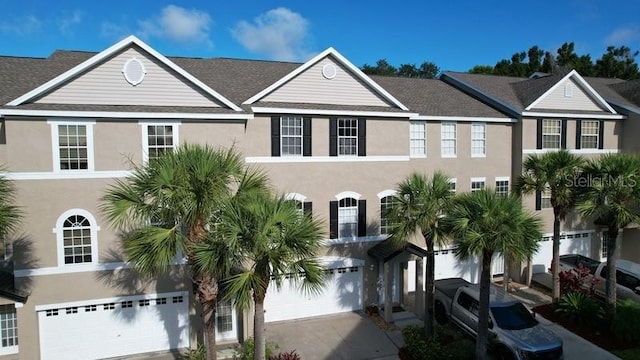 view of front of house featuring driveway, an attached garage, and stucco siding