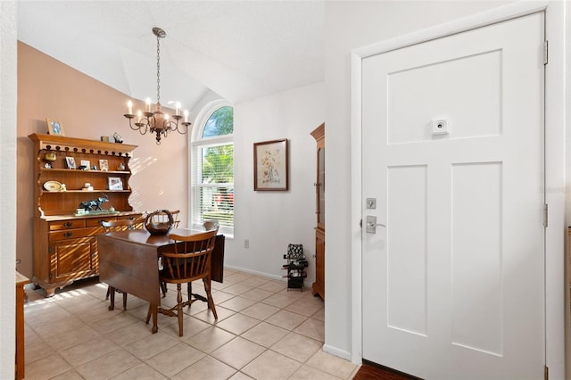 dining room with lofted ceiling, light tile patterned floors, a chandelier, and baseboards