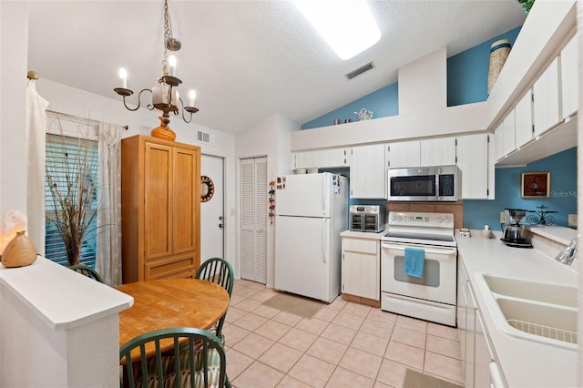 kitchen with white appliances, visible vents, light countertops, white cabinetry, and a sink