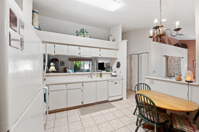 kitchen featuring light tile patterned floors, light countertops, white cabinetry, a sink, and white appliances