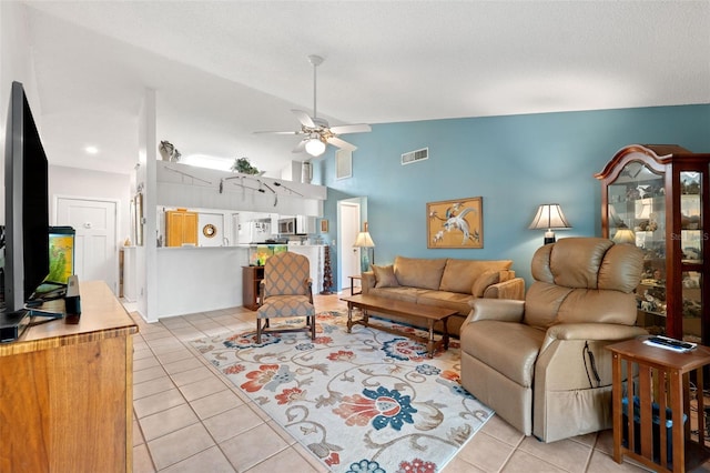 living room featuring light tile patterned floors, visible vents, lofted ceiling, ceiling fan, and a textured ceiling