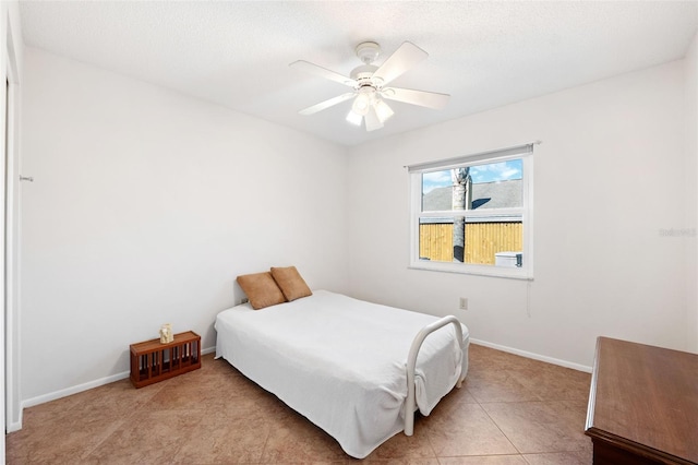 bedroom with light tile patterned floors, baseboards, and a ceiling fan