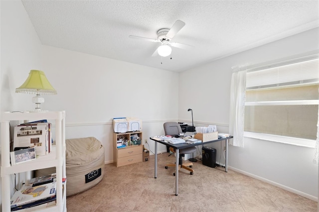 office with a ceiling fan, a textured ceiling, and baseboards