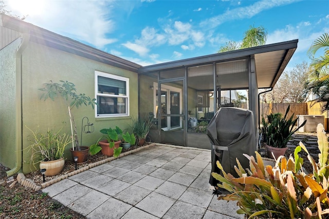 view of patio / terrace with a sunroom and fence