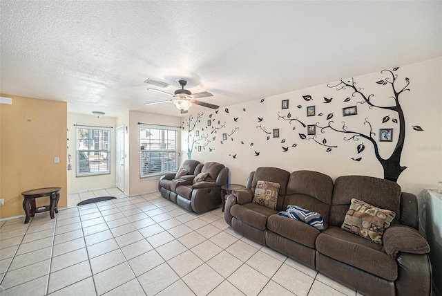 living room with a ceiling fan, visible vents, a textured ceiling, and light tile patterned flooring