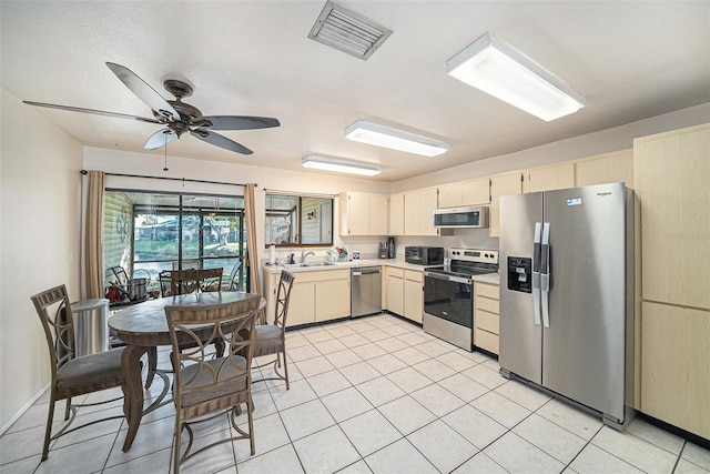 kitchen with light tile patterned floors, visible vents, stainless steel appliances, light countertops, and a sink