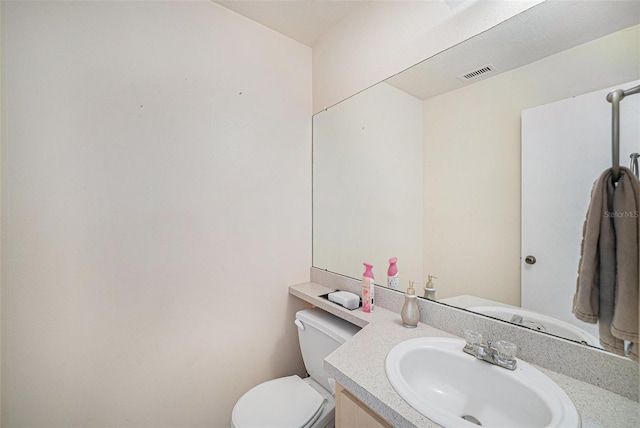 bathroom featuring visible vents, vanity, and toilet