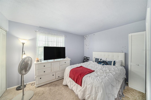 bedroom with a textured ceiling and light colored carpet