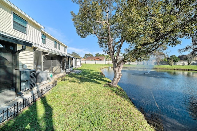 view of yard with a sunroom, a water view, and fence