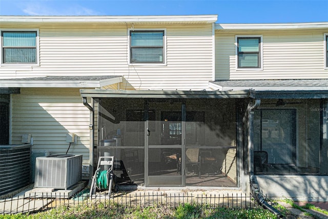 back of house featuring a sunroom, fence, and cooling unit