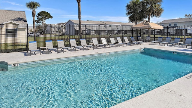 pool with a residential view, a patio area, and fence