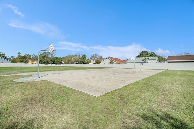 view of basketball court with a yard, community basketball court, and fence