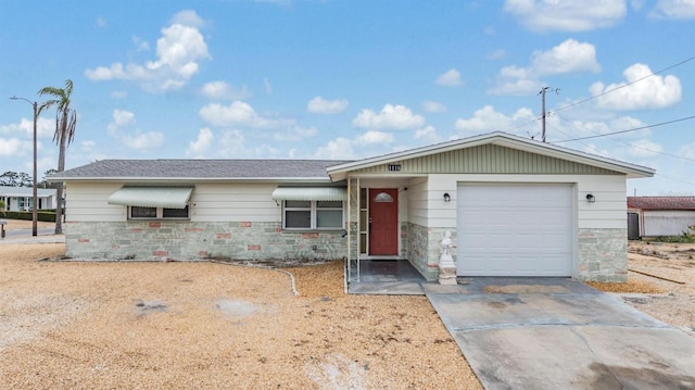 ranch-style house with stone siding, an attached garage, and concrete driveway