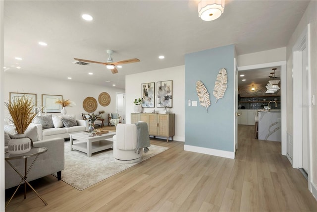 living area with recessed lighting, visible vents, and light wood-style floors