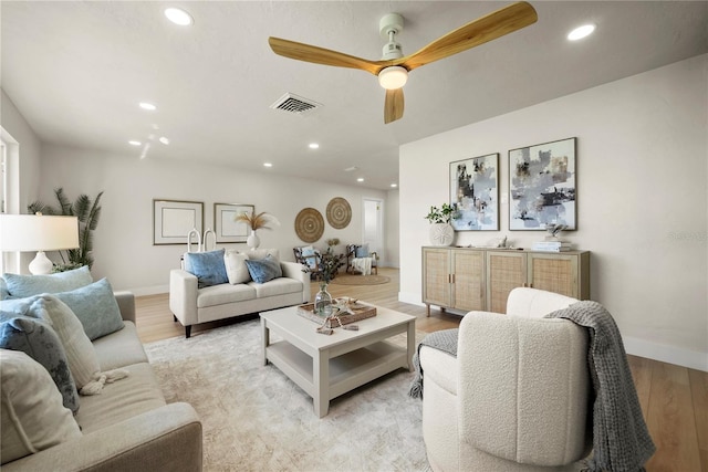 living area featuring visible vents, a ceiling fan, recessed lighting, light wood finished floors, and baseboards