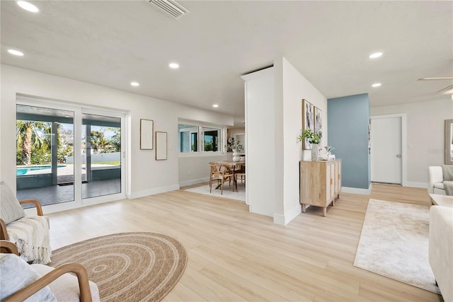 living area featuring recessed lighting, light wood-style flooring, baseboards, and visible vents