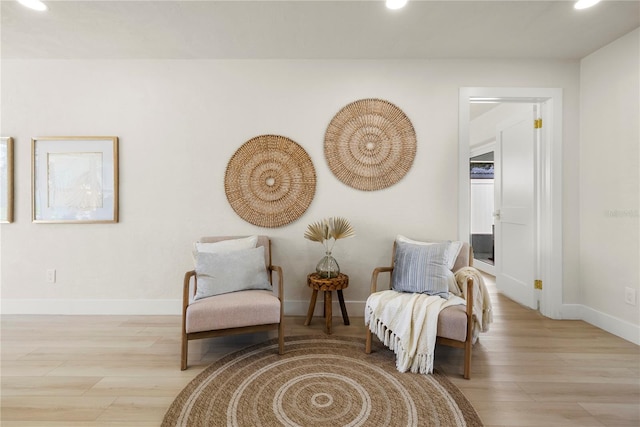 living area featuring recessed lighting, baseboards, and light wood-style floors