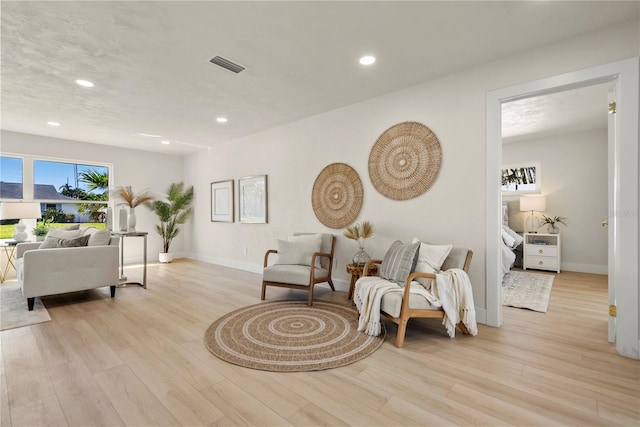 living area featuring recessed lighting, visible vents, baseboards, and light wood-style floors