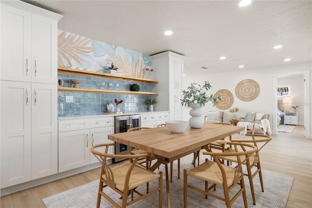 dining room featuring recessed lighting, light wood-type flooring, indoor bar, and beverage cooler