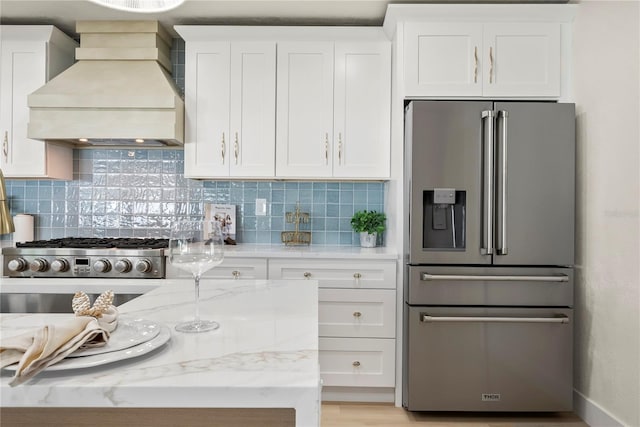 kitchen featuring white cabinetry, custom range hood, stainless steel fridge with ice dispenser, and tasteful backsplash