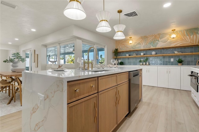 kitchen with visible vents, a center island with sink, a sink, open shelves, and stainless steel dishwasher