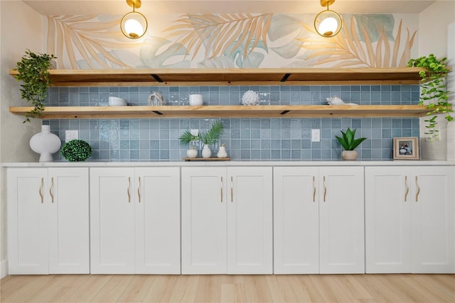 interior space with light wood-style floors and tasteful backsplash