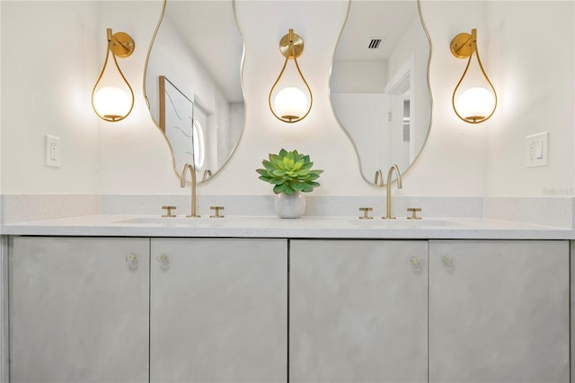 bathroom featuring double vanity, visible vents, and a sink