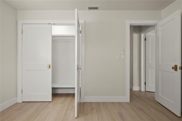 unfurnished bedroom with light wood-style floors, visible vents, a closet, and baseboards