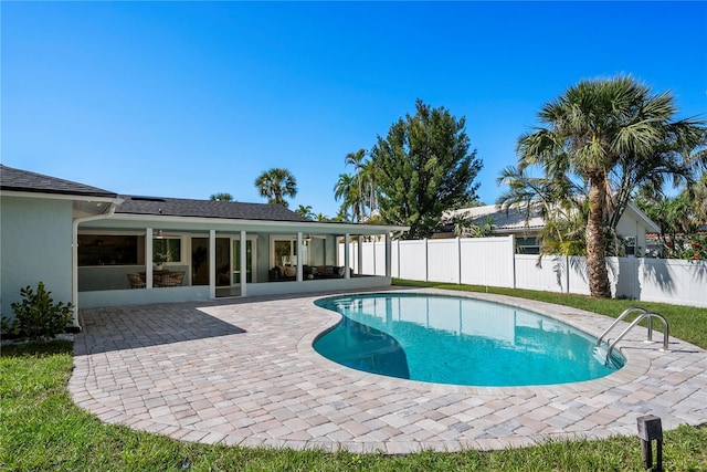 view of swimming pool featuring a fenced in pool, a sunroom, a fenced backyard, and a patio area