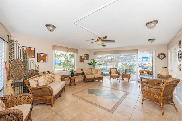 interior space with light tile patterned floors, ceiling fan, baseboards, and a healthy amount of sunlight