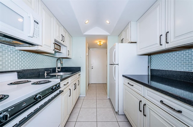 kitchen featuring light tile patterned flooring, recessed lighting, white appliances, a sink, and white cabinets