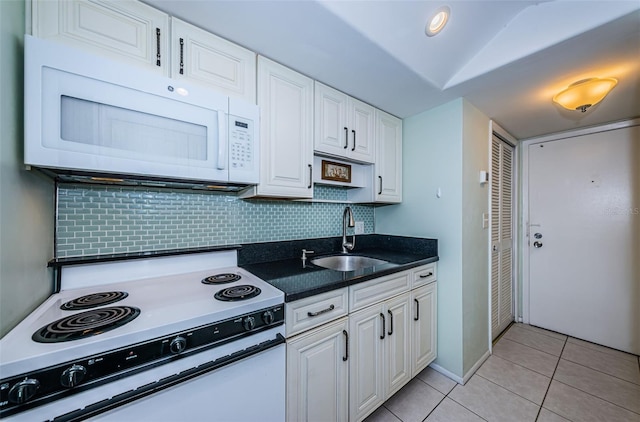 kitchen featuring white appliances, white cabinetry, a sink, and light tile patterned floors