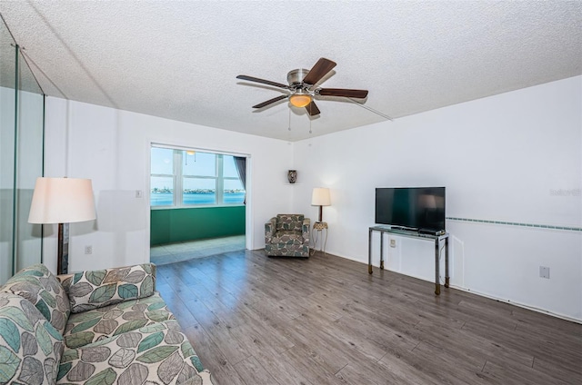 unfurnished living room with ceiling fan, a textured ceiling, and wood finished floors